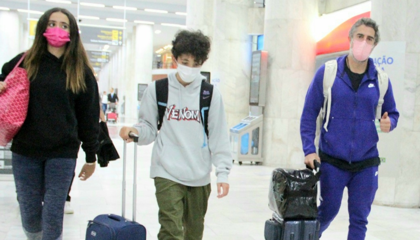 Marcos Mion ao lado dos filhos em aeroporto